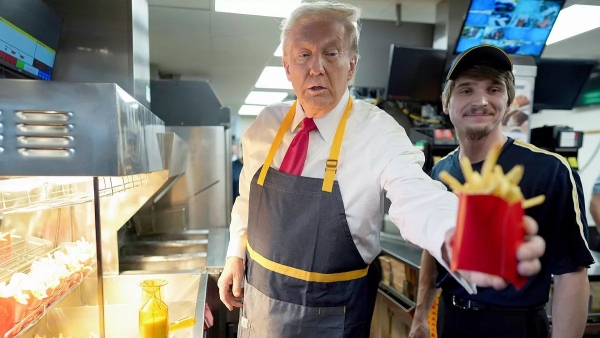 Donald J. Trump wearing an apron while dispensing french fries at a McDonald's fast food restaurant in Pennsylvania as part of a campaign stunt on Sunday, October 20, 2024. Photo by Doug Mills/AP.