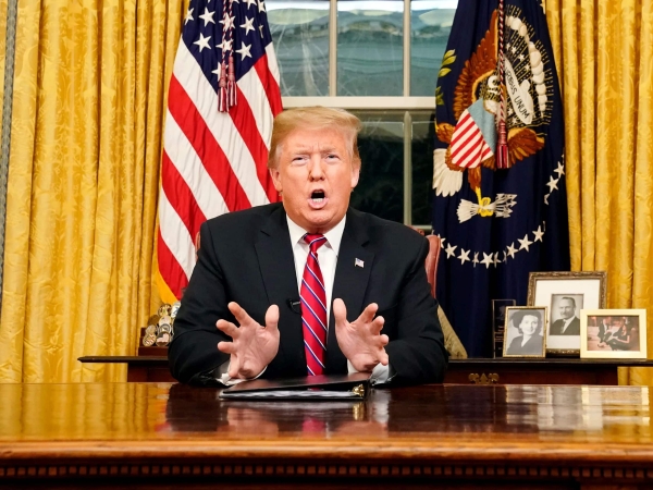 Trump in White House Oval Office behind Resolution Desk while giving an address. Photo: Carlos Berria/AP